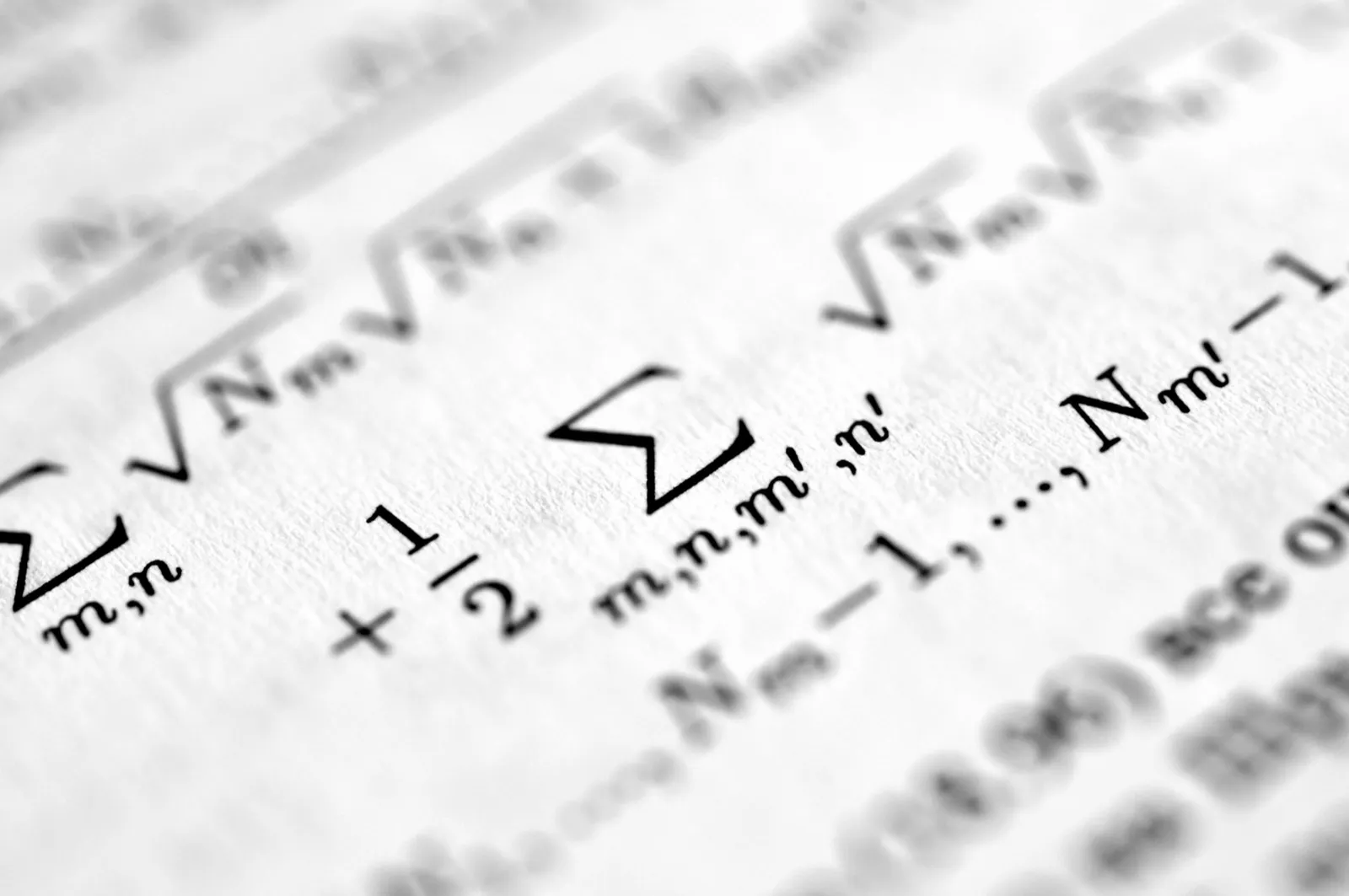 Formules mathématiques imprimées en gros plan, avec symboles de somme et racines carrées.